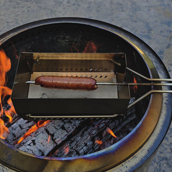 Video of a hot dog being rotated on the skewer over an open fire. Cooked to perfection.