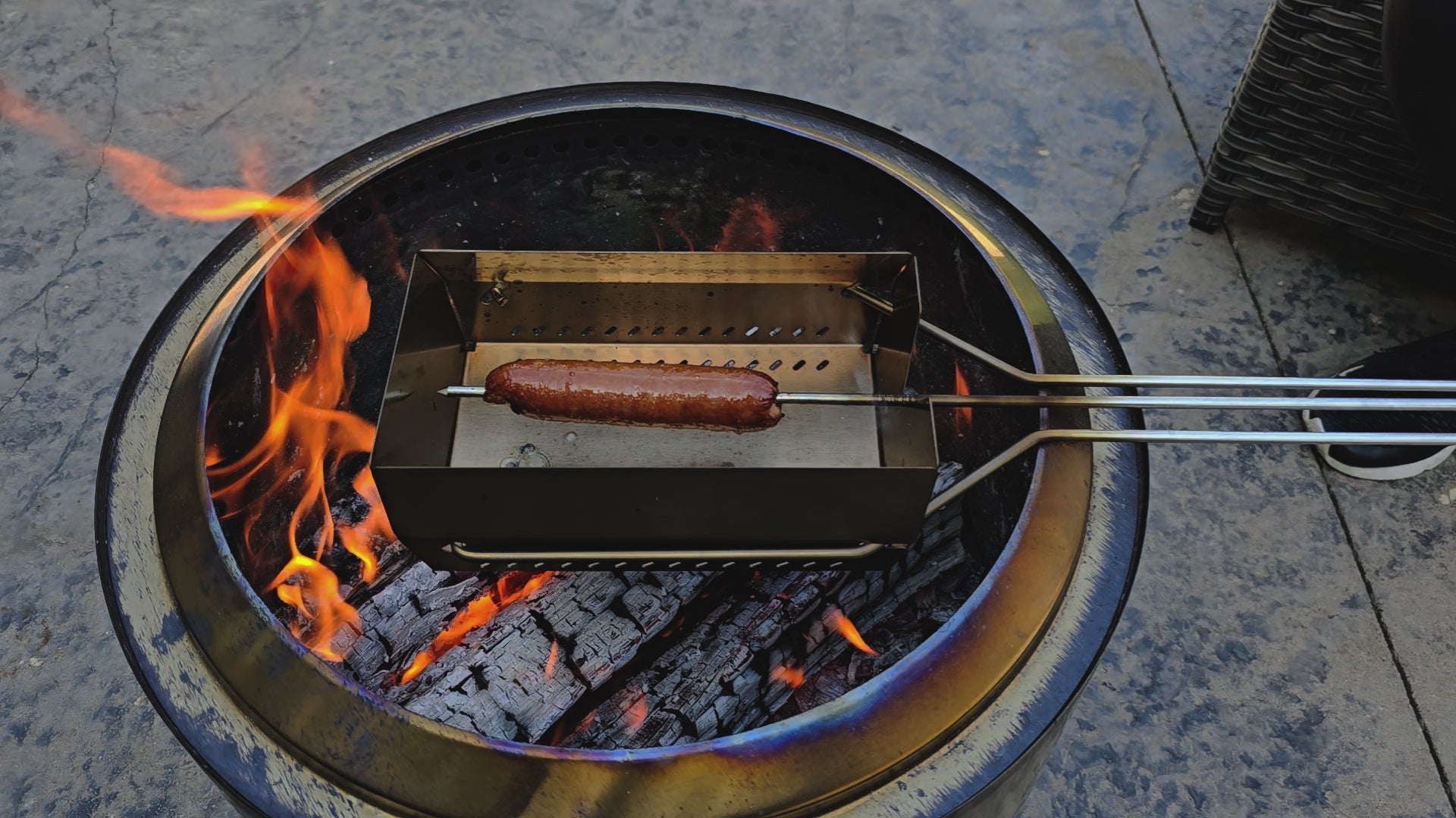 Video of a hot dog being rotated on the skewer over an open fire. Cooked to perfection.